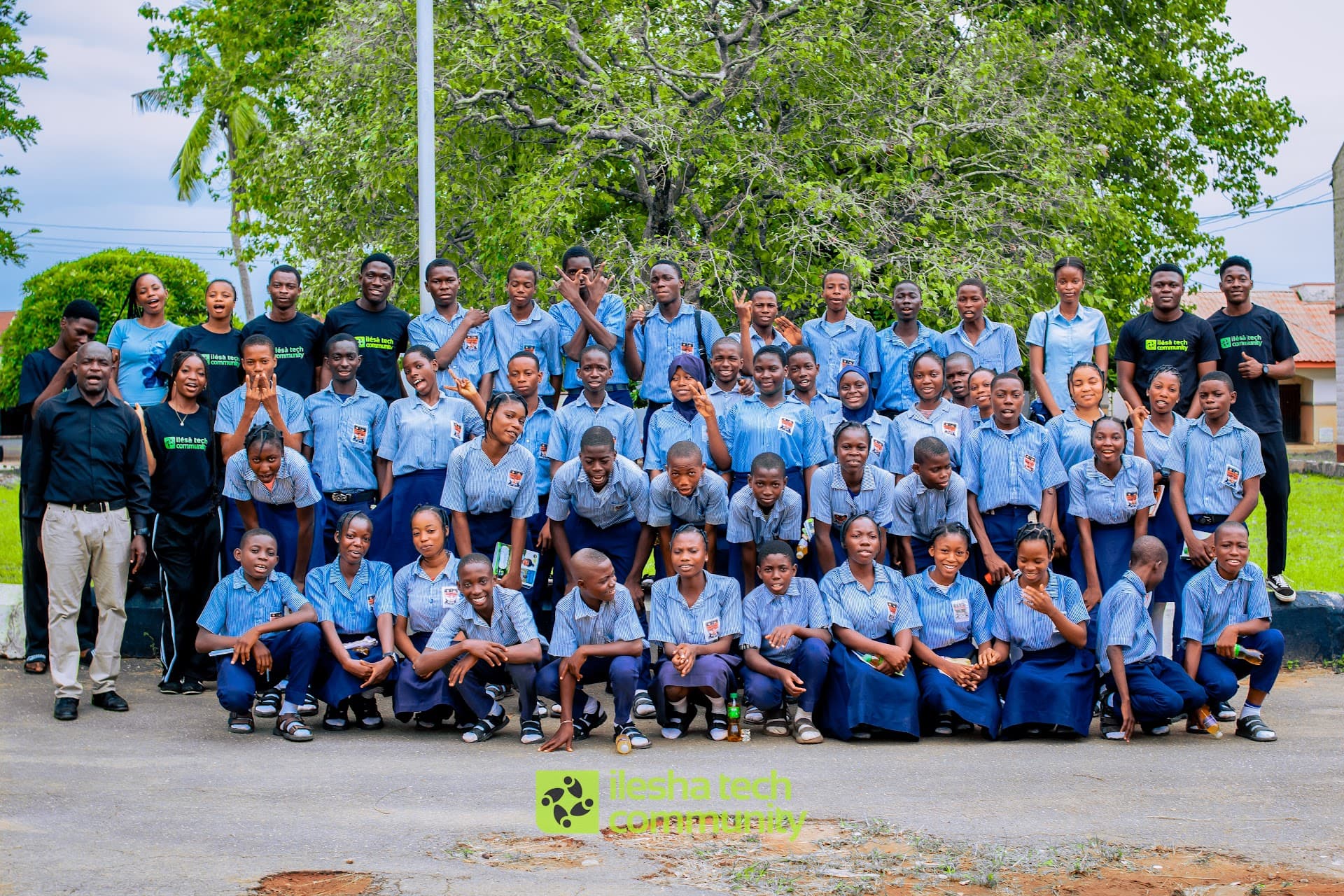 School students in blue uniforms gathered with Ilesa Tech community members during school outreach